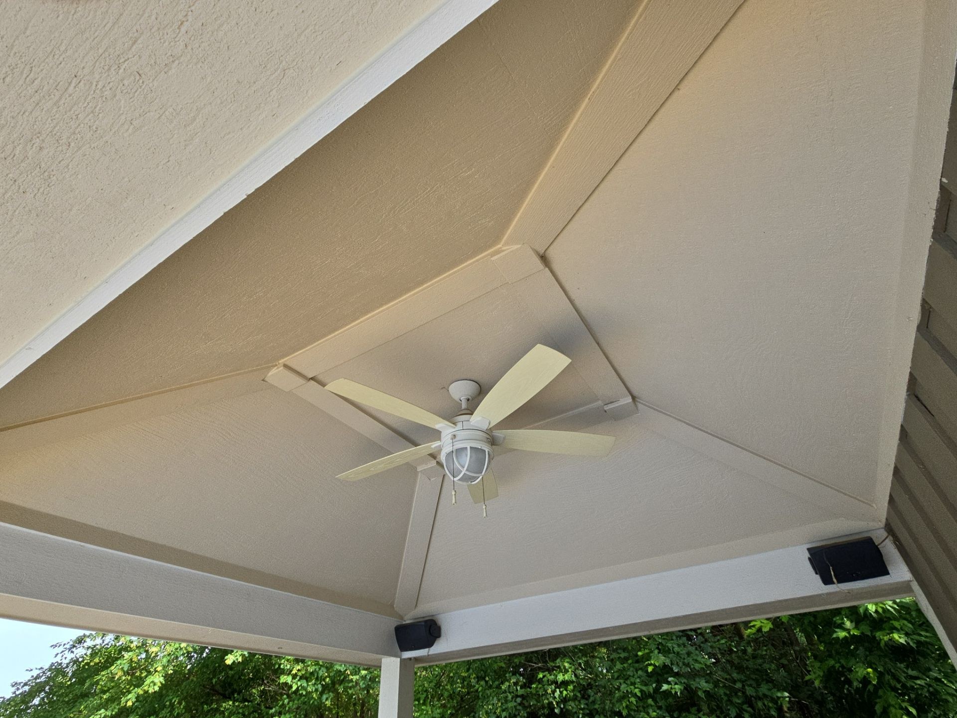 Covered outdoor ceiling with painted beams and trim at a Hubertus property