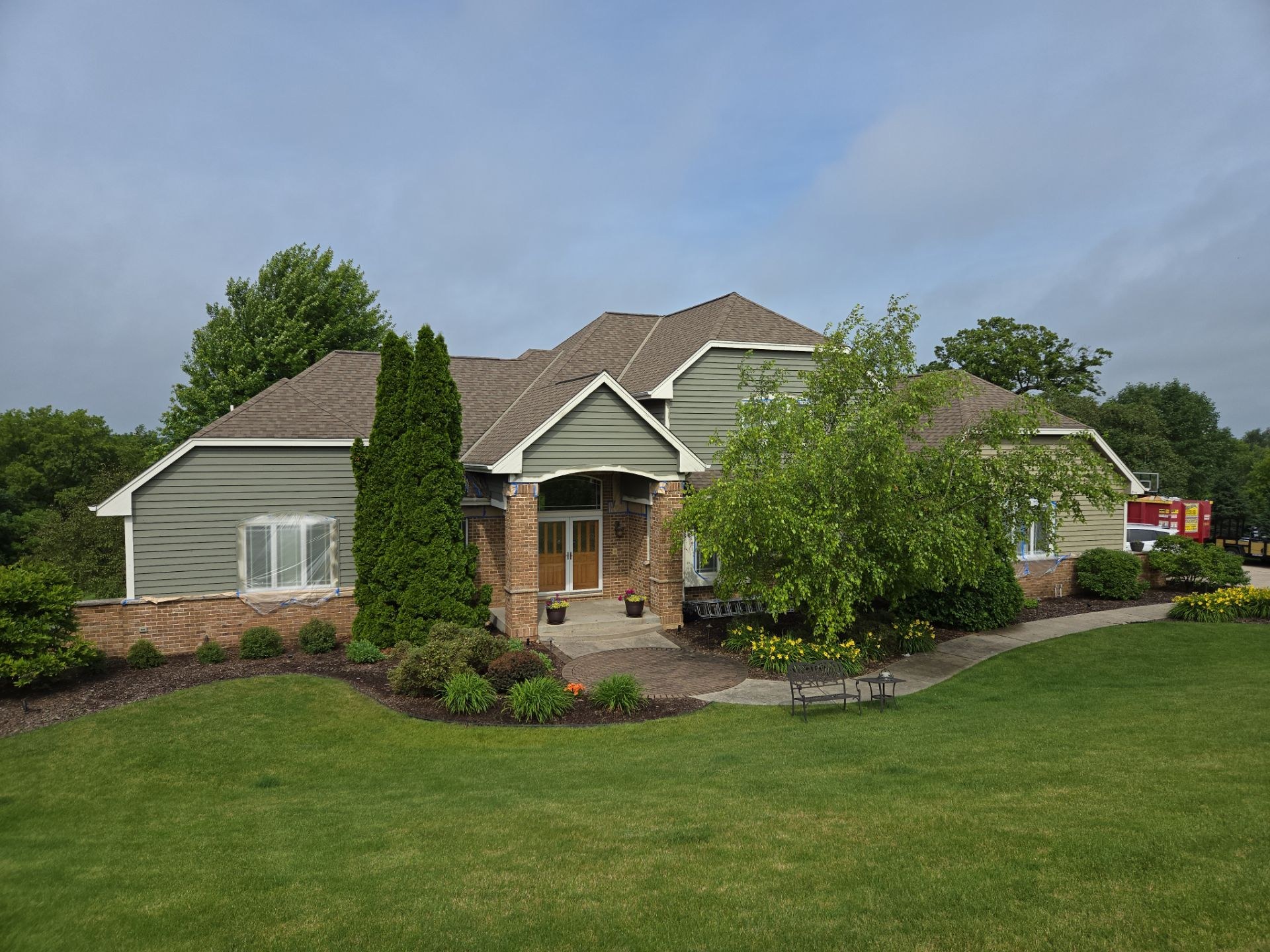 Hubertus home with green siding, white trim and masking over front windows