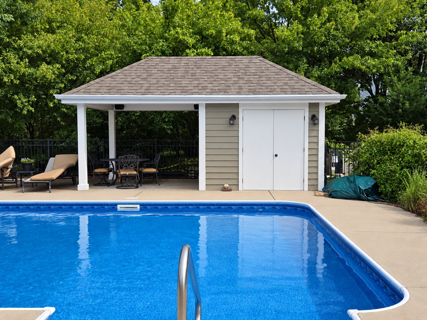 Poolside building with green siding, white posts and double doors in Hubertus, Wisconsin