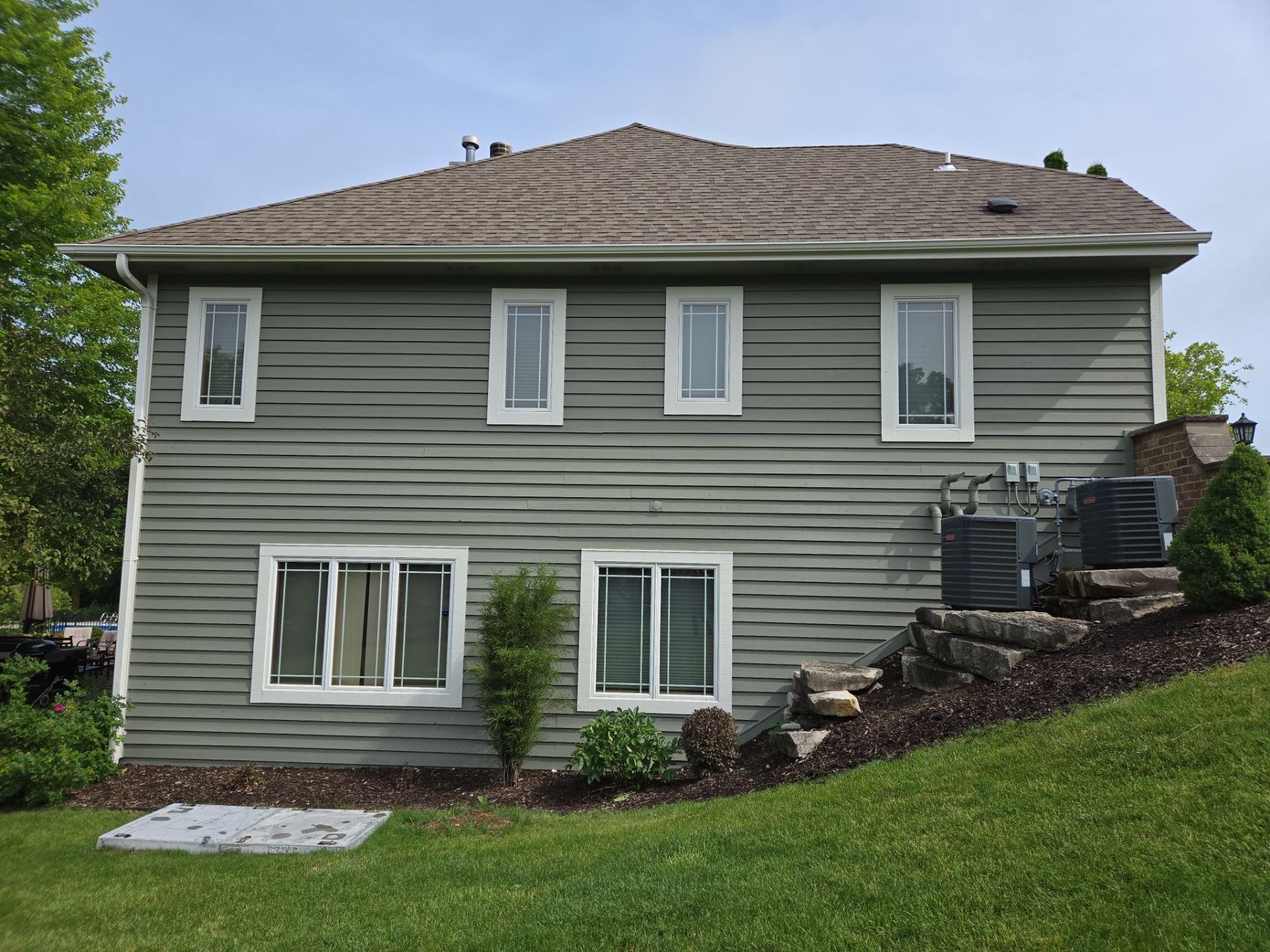 Green horizontal siding and white window trim on a Hubertus home