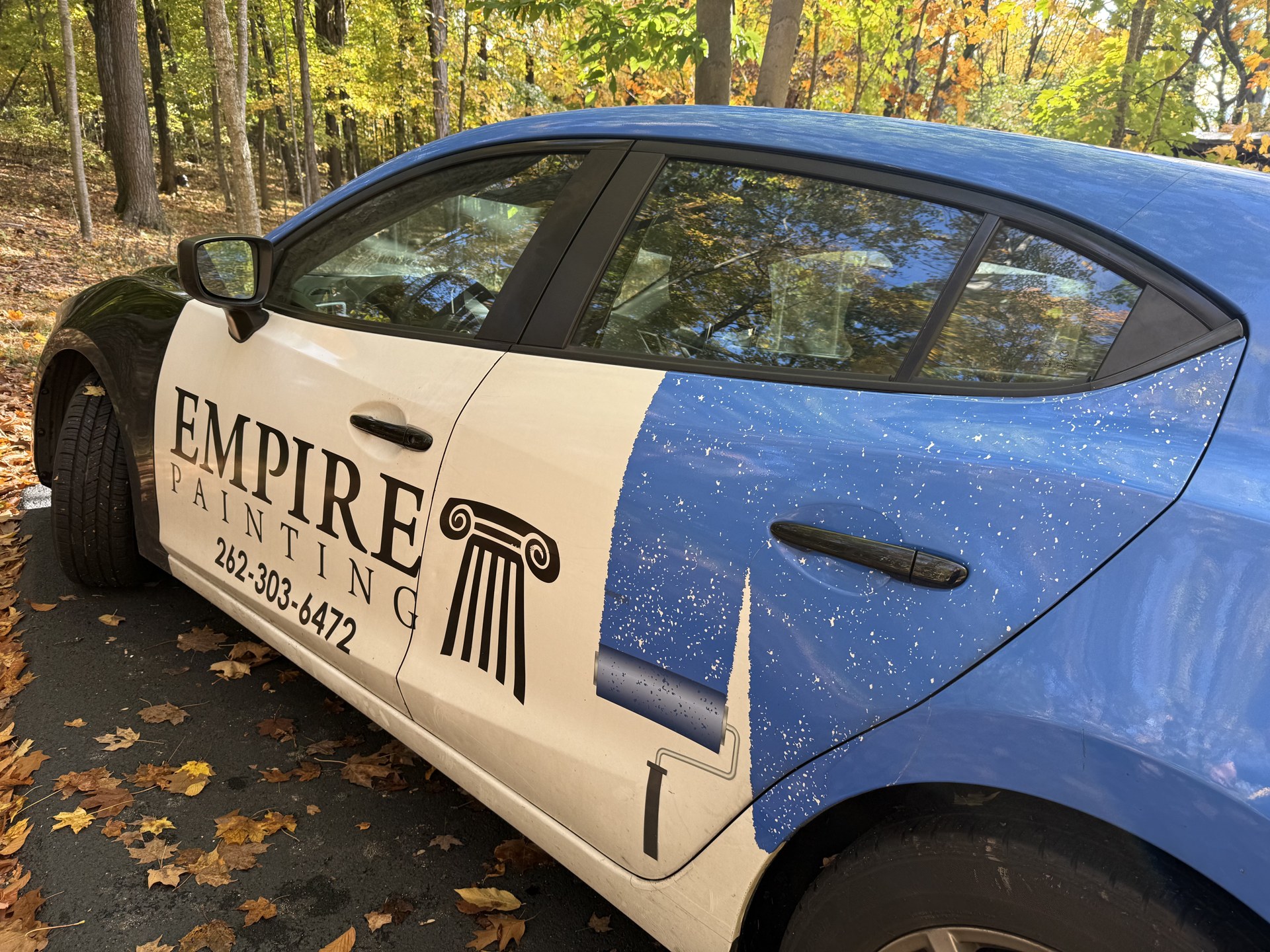 Empire Painting vehicle parked among autumn trees during a Hubertus estimate visit