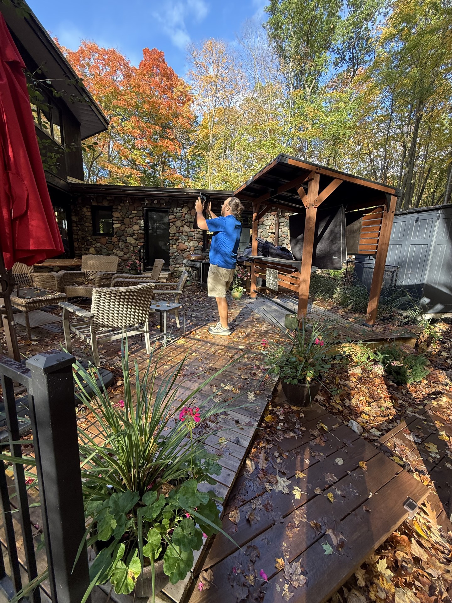 Matt Hoskins using a tablet during an exterior painting estimate at a wooded Hubertus property