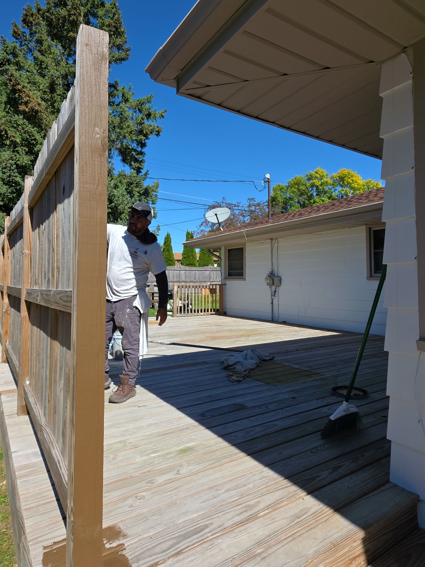Empire crew working on a Menomonee Falls deck with original wood and stained sections visible