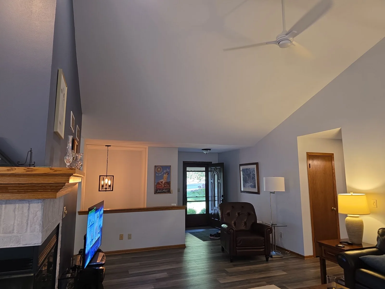 Waukesha living room with light walls, vaulted ceiling and stone fireplace