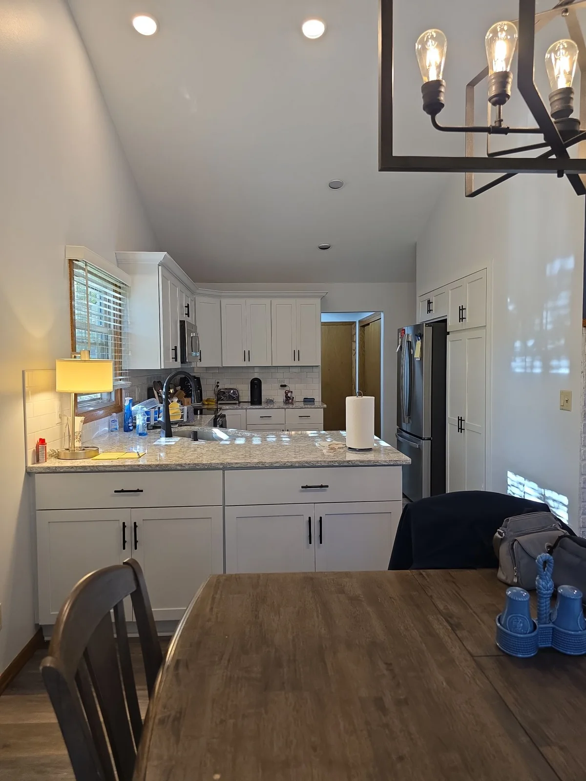 Kitchen and dining area with light walls and existing cabinetry