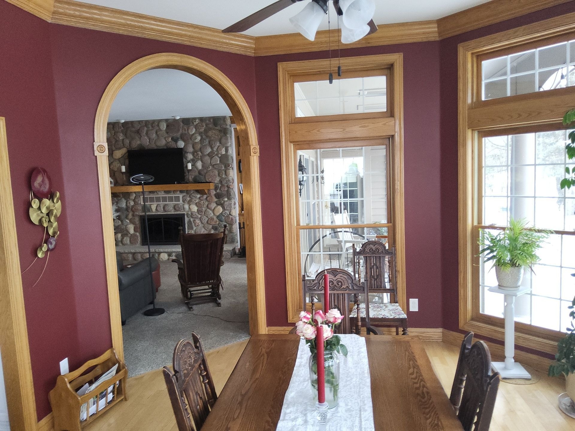 Wood-trimmed arch connecting a burgundy dining room to the living area
