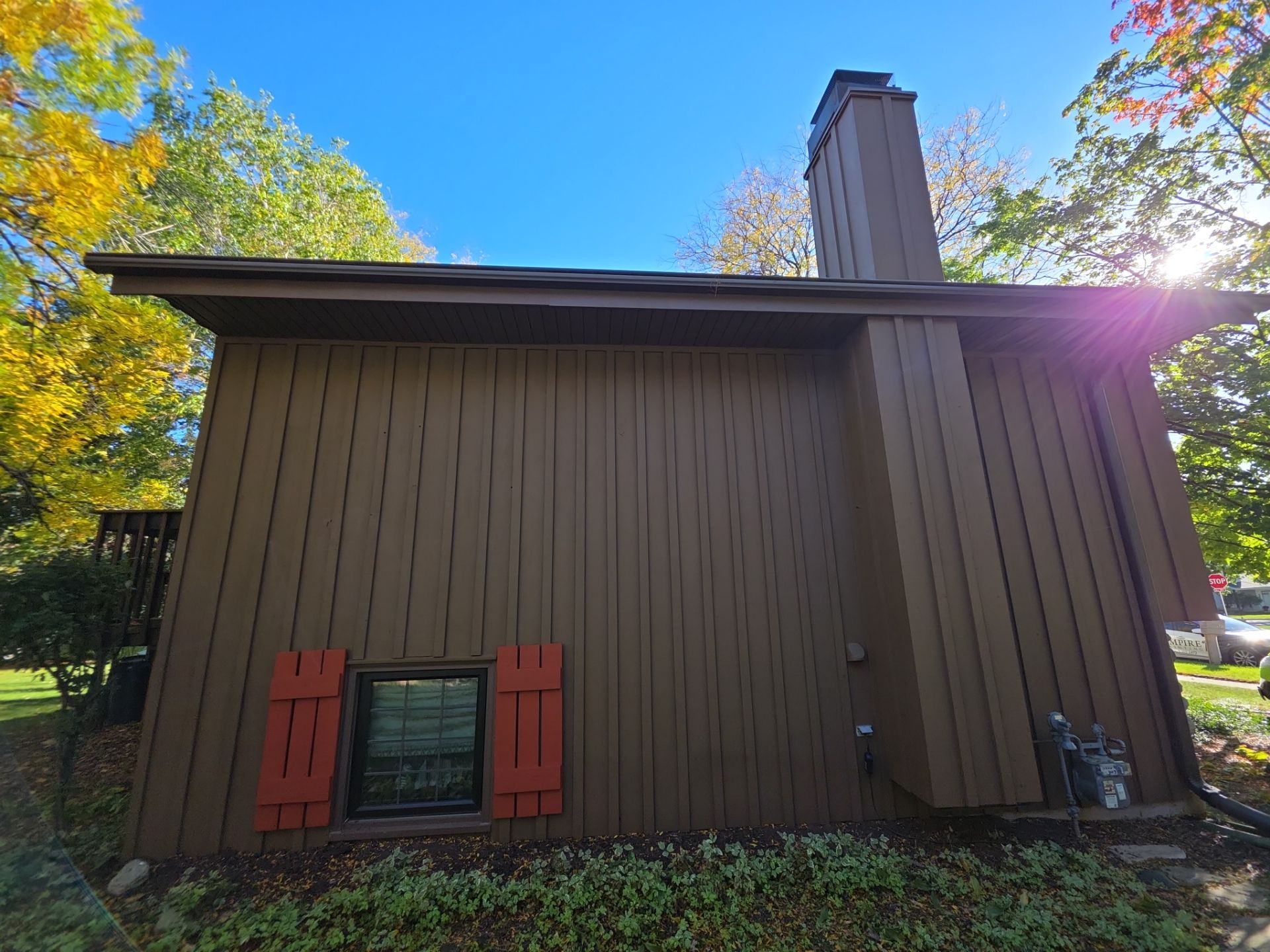 Waukesha exterior wood siding and chimney viewed from the backyard